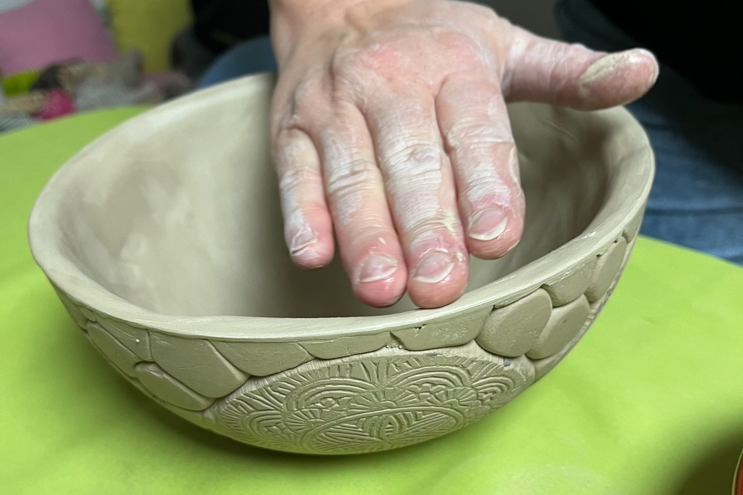 Töpferkurse bei Erlebnislabor Eine Hand formt beim Töpfern eine Schüssel in einem Töpferkurs von Erlebnislabor